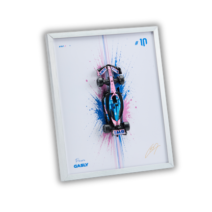 A framed wall art print featuring a stylized pink and blue Formula 1 race car on a white background with paint splatter graphics. The frame is white, and the print includes the text 'Piero GASLY' and '#10' in blue, with a gold signature in the lower right.