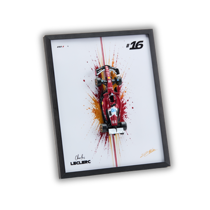 A framed art print featuring a red Formula 1 race car on a white background with paint splatter effects, a black frame, and the name Charles Leclerc printed at the bottom.