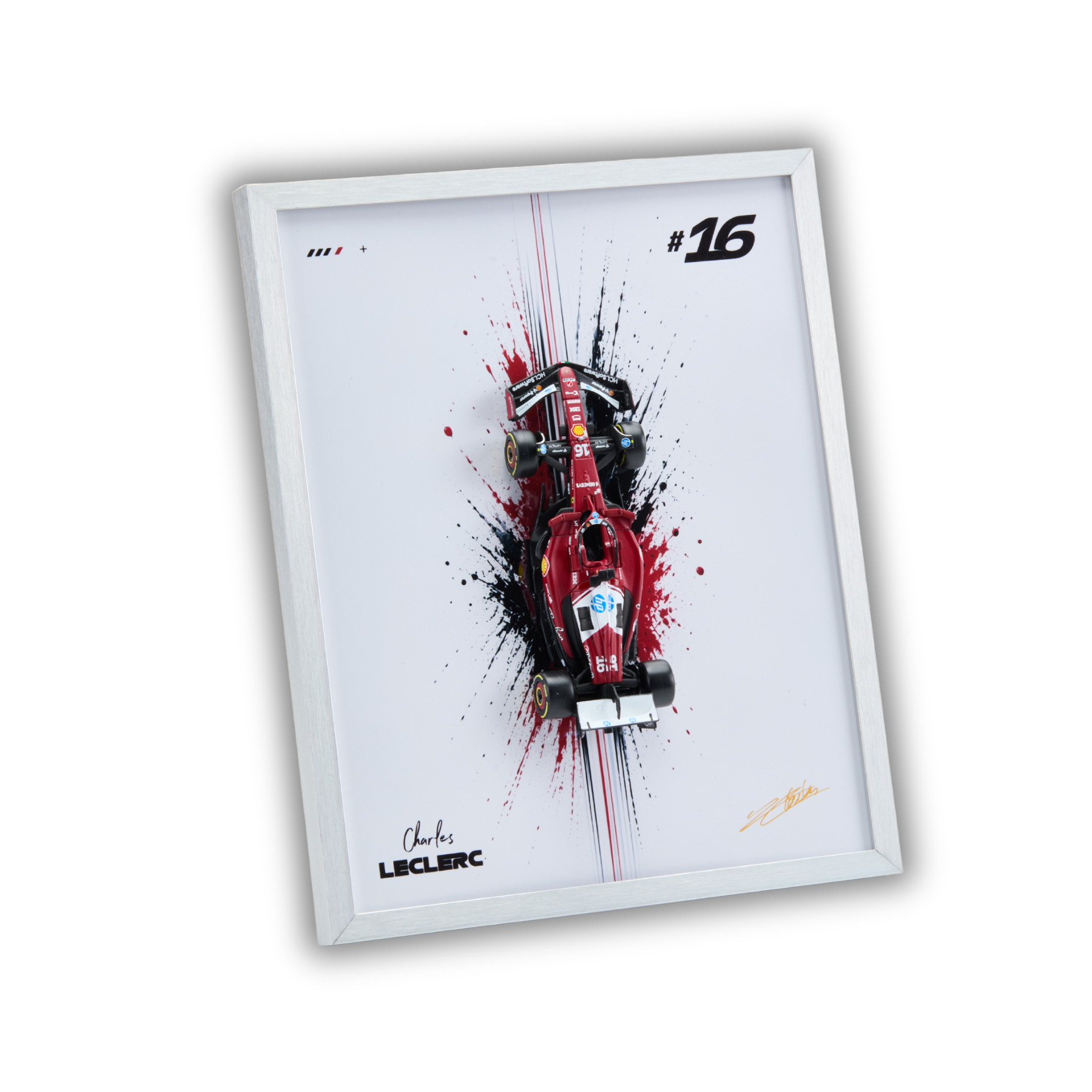 A framed wall art print featuring a stylized red Formula 1 race car with black and red paint splatters on a white background, shown at an angle against a black backdrop.