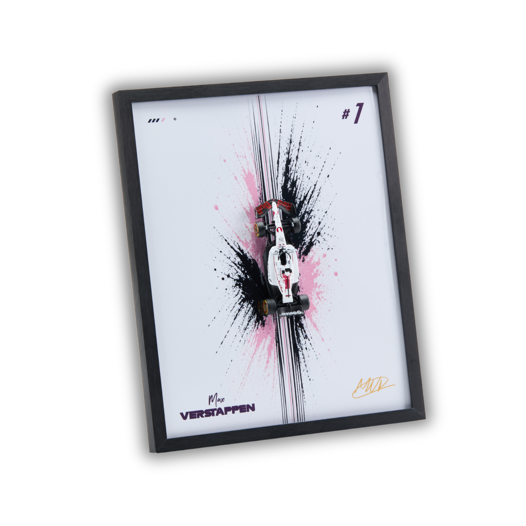 A framed art print featuring a miniature white and red Formula 1 car on a white background with black and pink paint splatters, enclosed in a black frame.