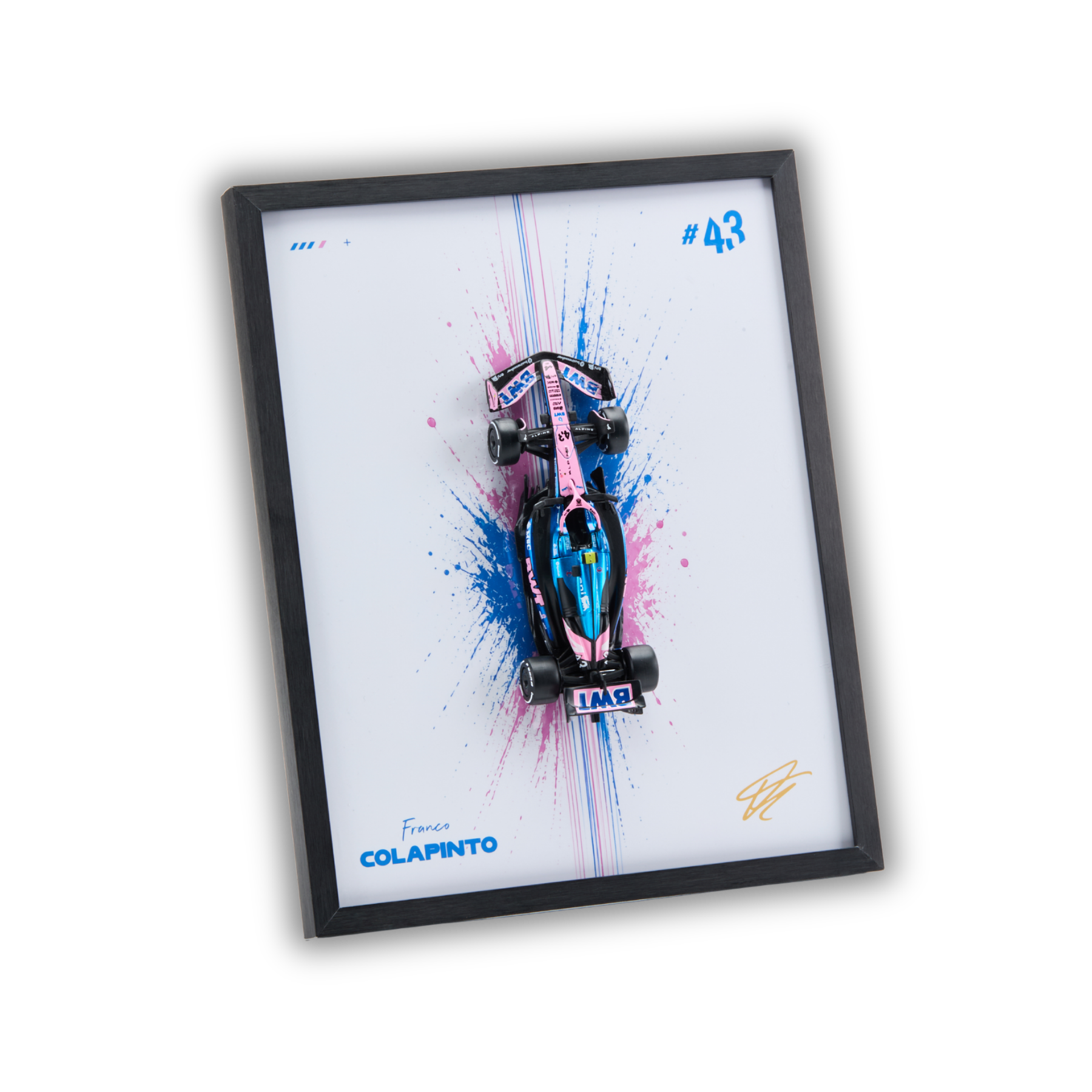 A framed wall art print featuring a pink and blue miniature Formula 1 race car mounted over a white background with paint splatter graphics. The print includes the text 'France COLAPINTO', '#43', and a gold signature, all enclosed in a black frame on a white background.