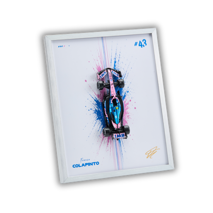 A framed wall art print featuring a stylized Formula 1 car in pink, blue, and black over a white background with paint splatter, shown at an angle on a black backdrop.