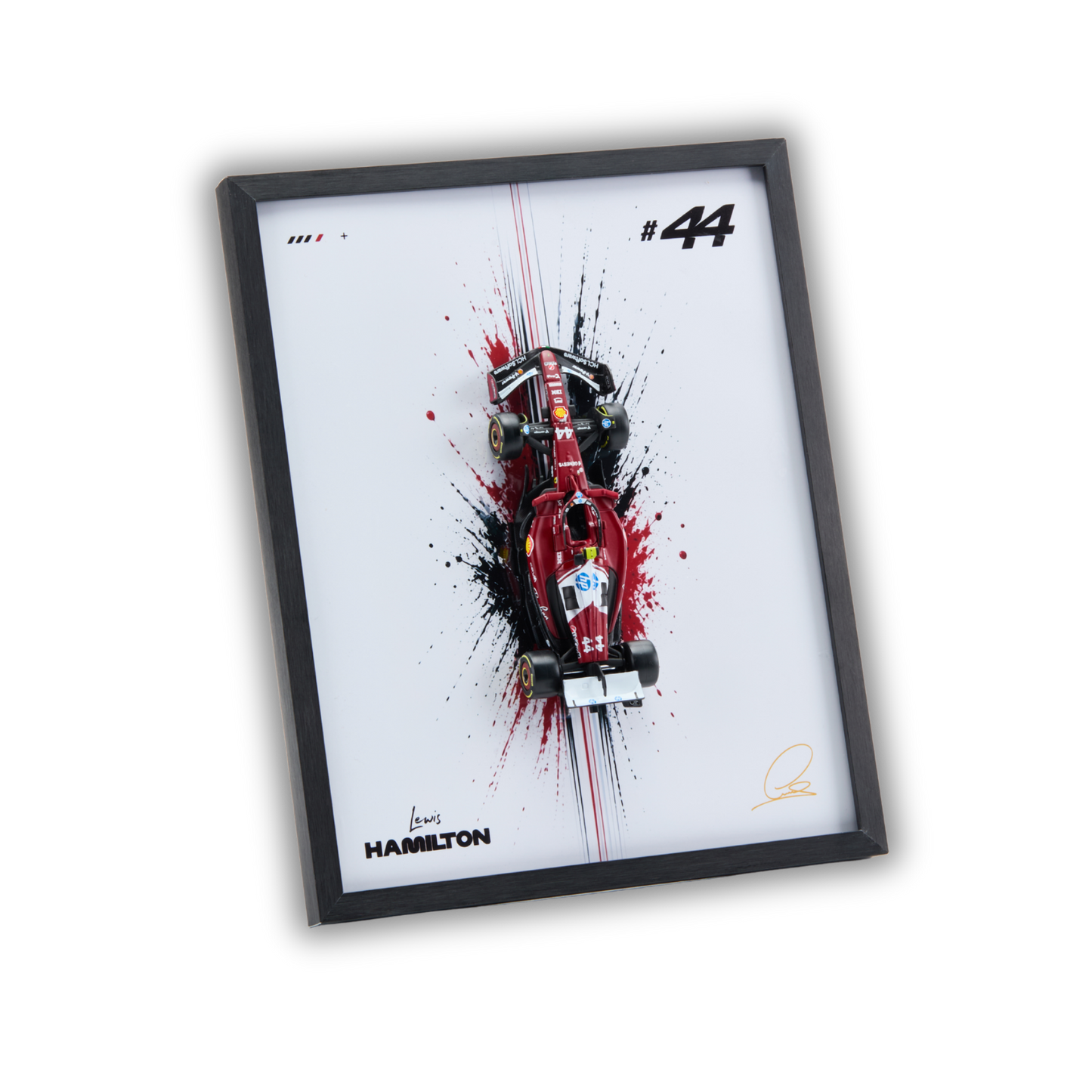 A framed art print featuring a red Formula 1 race car with black and red paint splatters on a white background, enclosed in a black frame. The print includes the number 44, the name Hamilton, and signatures.