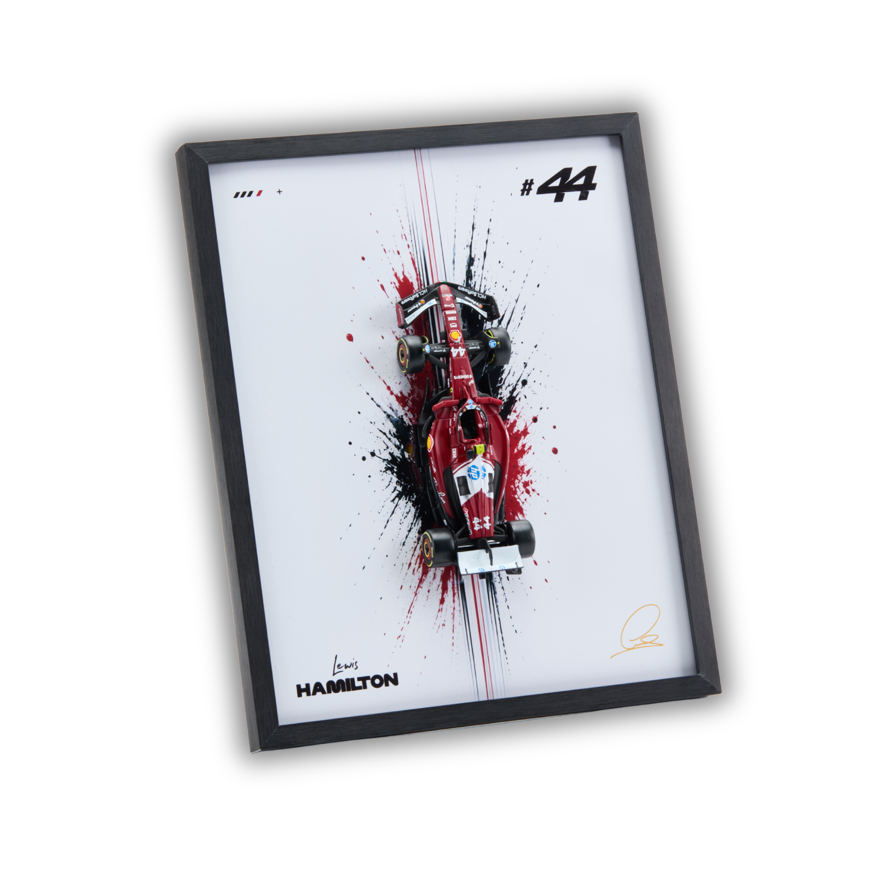 A framed art print featuring a red Formula 1 race car with black and red paint splatters on a white background, enclosed in a black frame. The print includes the number 44, the name Hamilton, and signatures.