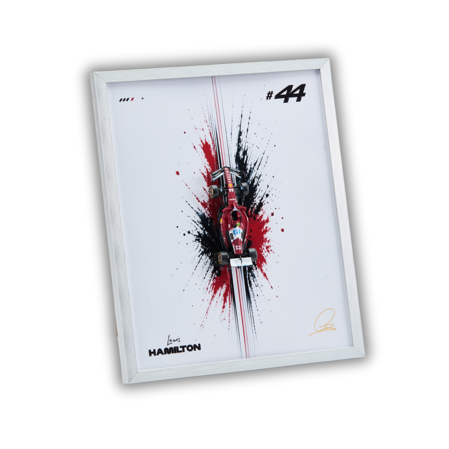 A framed art print featuring a stylized red and black Formula 1 car splash design on a white background, with the number 44, Hamilton branding, and a silver frame, shown on a plain white background.