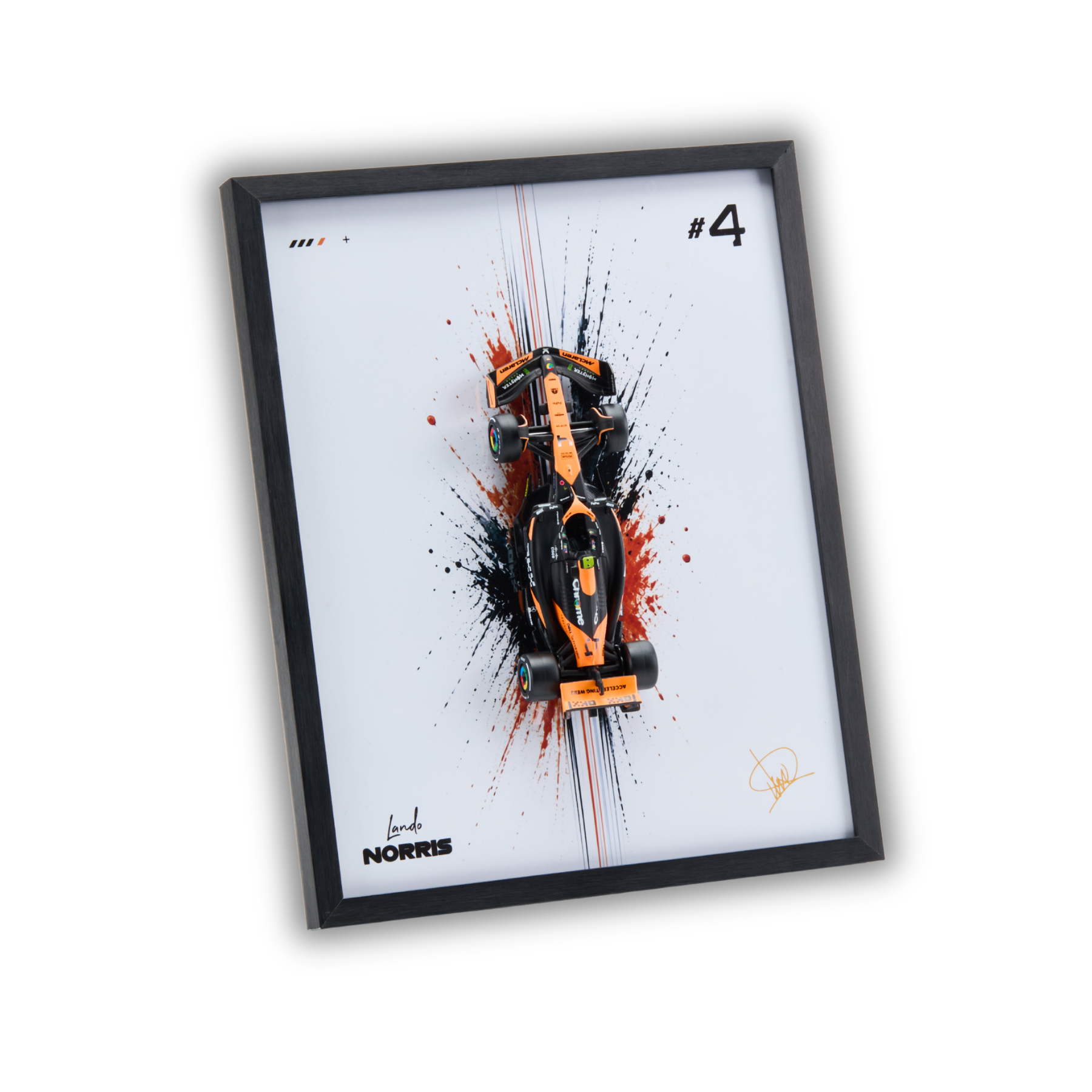 A framed art print featuring a top-down view of an orange and black Formula 1 race car over a white background with red and black paint splatters. The print includes the text '#4' and 'NORRIS' along with a signature, all enclosed in a black frame.
