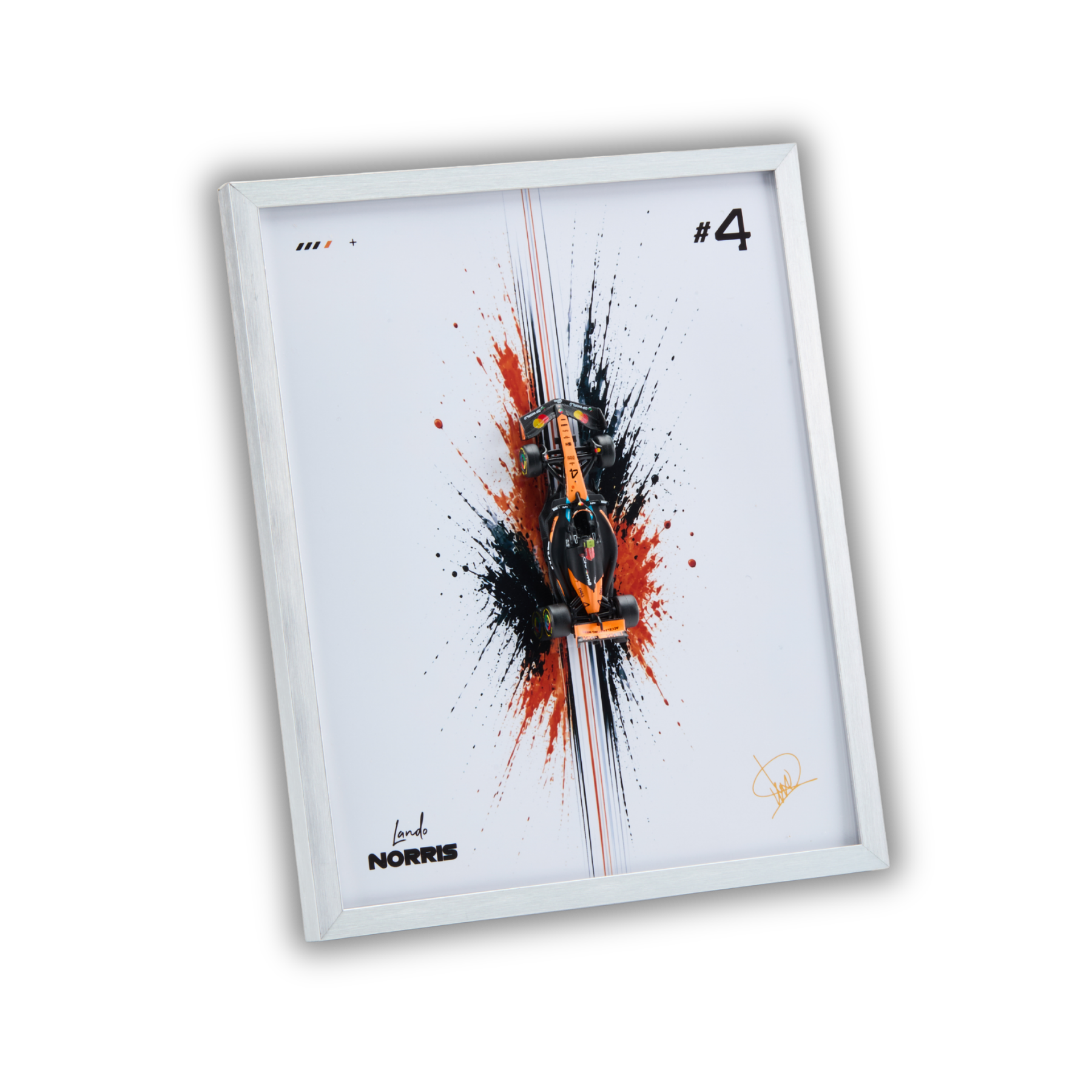 A framed art print featuring a stylized orange and black Formula 1 car centered over a red and black paint splatter design on a white background, with the text '#4' and 'L Norris' visible. The print is housed in a slim white frame and shown at an angle against a black background.