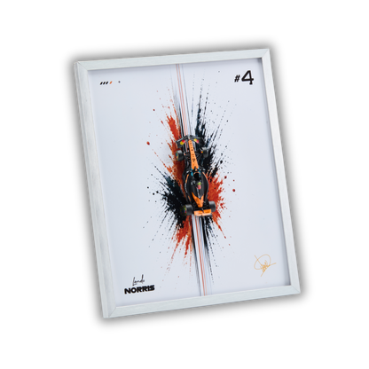 A framed art print featuring a stylized orange and black Formula 1 car centered over a red and black paint splatter design on a white background, with the text '#4' and 'L Norris' visible. The print is housed in a slim white frame and shown at an angle against a black background.