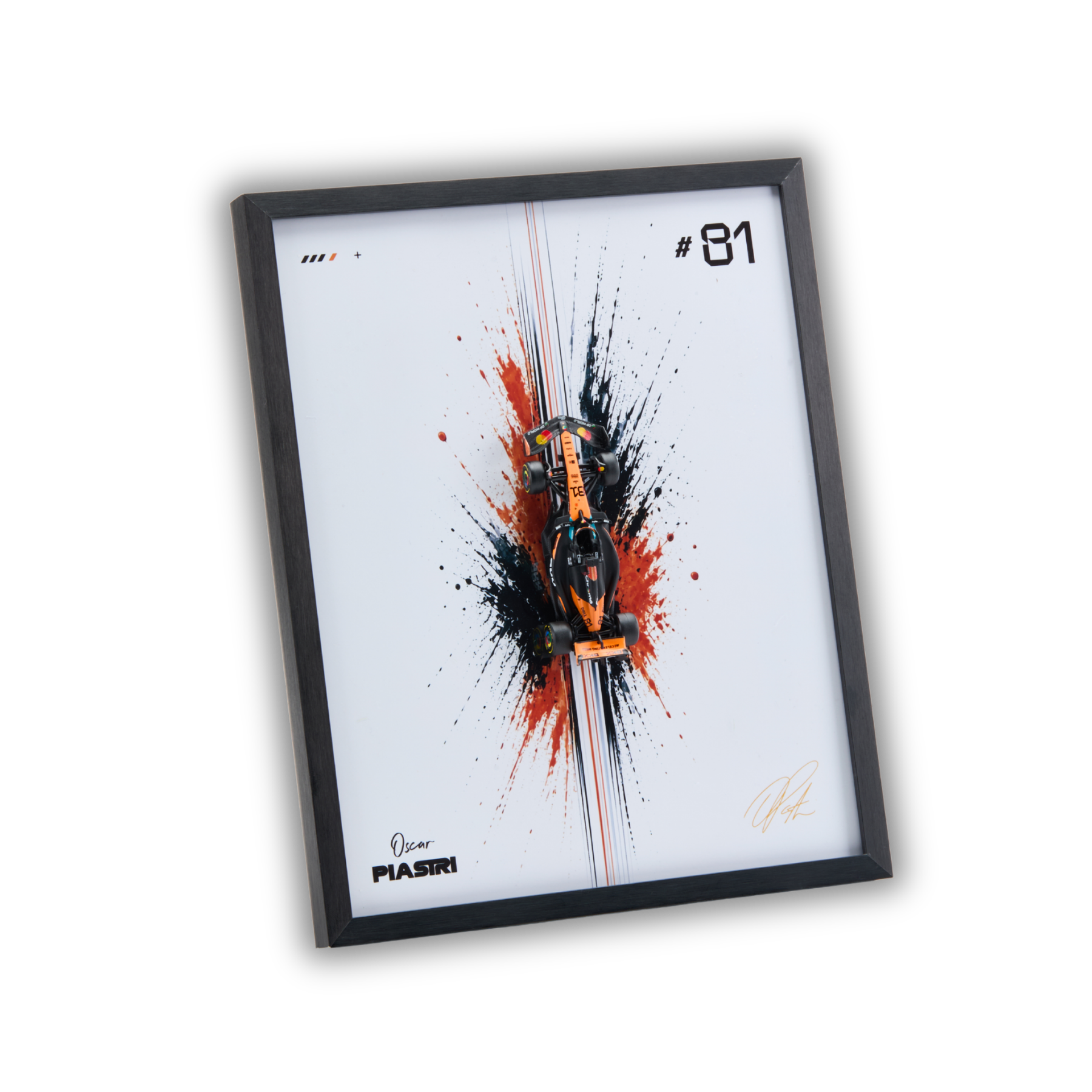 A framed art print featuring a stylized orange and black Formula 1 car centered over a white background with red and black paint splatters, a black frame, and the text '#81' plus a signature. The frame is shown at an angle on a plain white background.