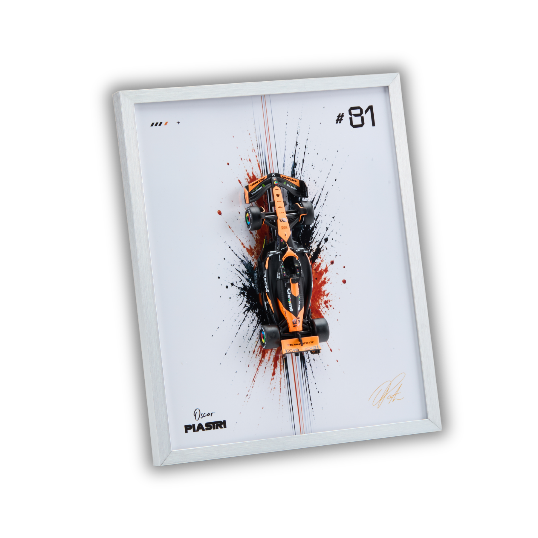 A framed art print featuring a stylized orange and black Formula 1 race car on a white background with paint splatter effects, the number 81, and signatures. The frame is light gray, and the print is shown at an angle on a plain white background.